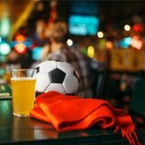 fußball schal und bierglas auf einer theke in einer bar