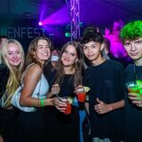 Fünf junge Menschen strahlen mit Drinks in der Hand in die Kamera.