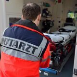 Ein Notarzt im Einsatz am Rettungswagen (Symbolbild)