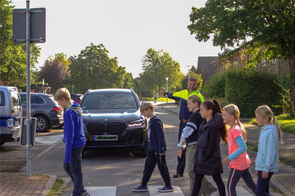 Polizist hilft Kindern über den Zebrastreifen. Polizist hilft Kindern über den Zebrastreifen.