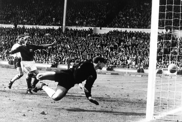 Der vom englischen Stürmer Geoff Hurst (nicht im Bild) geschossene Ball knallt von der Latte auf den Boden. Der deutsche Torhüter Hans Tilkowski (vorn) schaut sich im Hechten um, Abwehrspieler Wolfgang Weber (l) und der jubelnde englische Stürmer Roger Hunt schauen zu. Das sogenannte Wembley-Tor machte Hans Tilkowski berühmt.