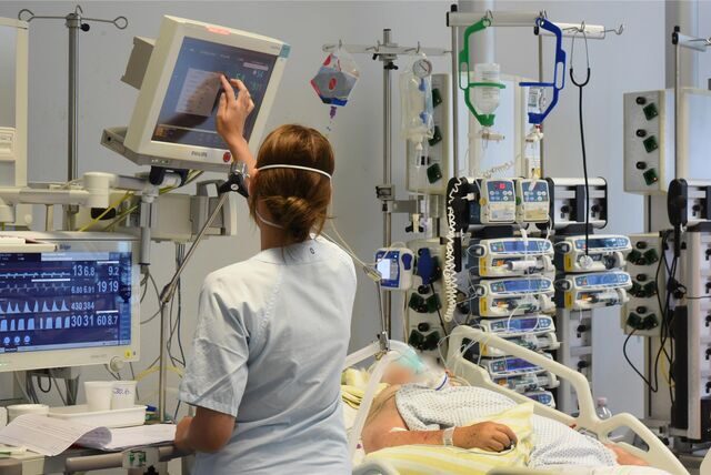 Auf der Intensivtherapie-Station (ITS) im Klinikum St. Georg steht eine Mitarbeiterin am Bett einer Patientin.