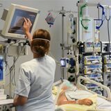 Auf der Intensivtherapie-Station (ITS) im Klinikum St. Georg steht eine Mitarbeiterin am Bett einer Patientin.
