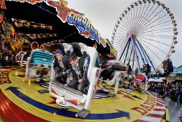 Besucher fahren bei der Kirmes „Pützchens Markt“ in Bonn mit dem Fahrgeschäft „Comander“.