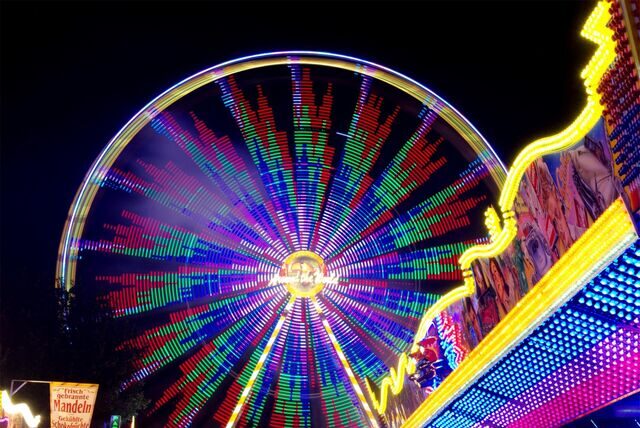 Das Riesenrad „Around the World“ dreht sich auf der Hüstener Kirmes in der Dunkelheit.