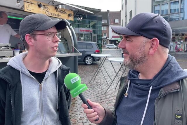 Blick auf eine Reihe von Verkaufsbuden mit vielen Menschen davor.