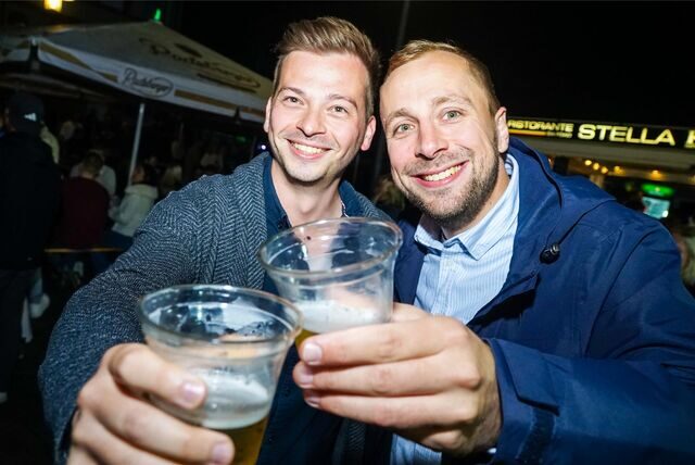 Besucher des Recklinghäuser Abendmarktes halten ihre Bierbecher in die Kamera