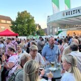 Menschen stehen über den Platz vor dem Feuerwehr verteilt.