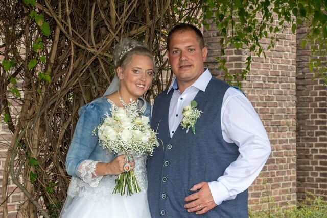 Annika Reisaus und Christopher Reisaus-Bieda unter einem Dach aus Zweigen am Standesamt. Regen zum Hochzeitstag kann ein gutes Omen sein.