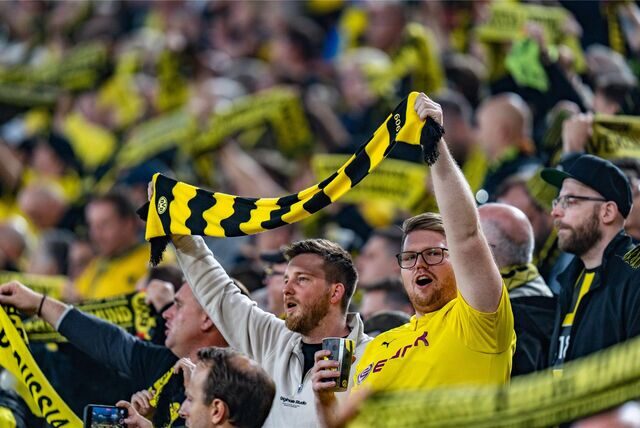 BVB-Fans halten auf der Südtribüne einen Schal hoch.
