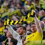 BVB-Fans halten auf der Südtribüne einen Schal hoch.