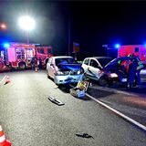 Feuerwehrleute untersuchen zwei Autos nach einem Unfall.