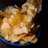 Eine Schüssel mit Kartoffelchips steht auf einem Tisch.