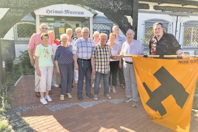 Eine Delegation der früheren KAB St. Peter überreicht ihr Banner am Heimatmuseum.