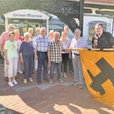 Eine Delegation der früheren KAB St. Peter überreicht ihr Banner am Heimatmuseum.