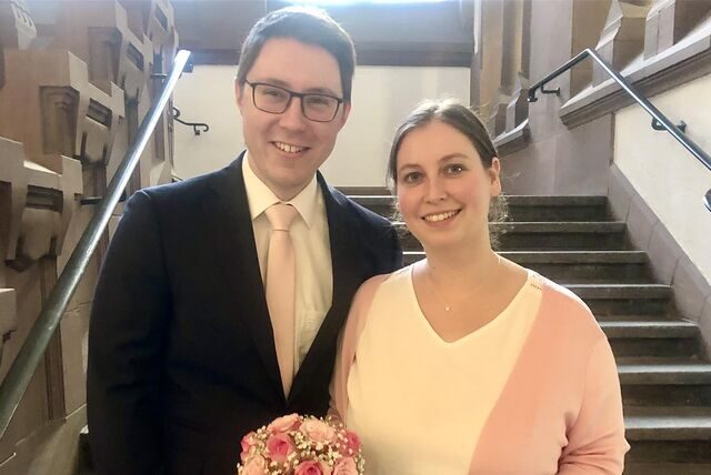 Jana Richter und Eric Rosthoff vor einer Treppe im Innern des Rathauses in Recklinghausen.