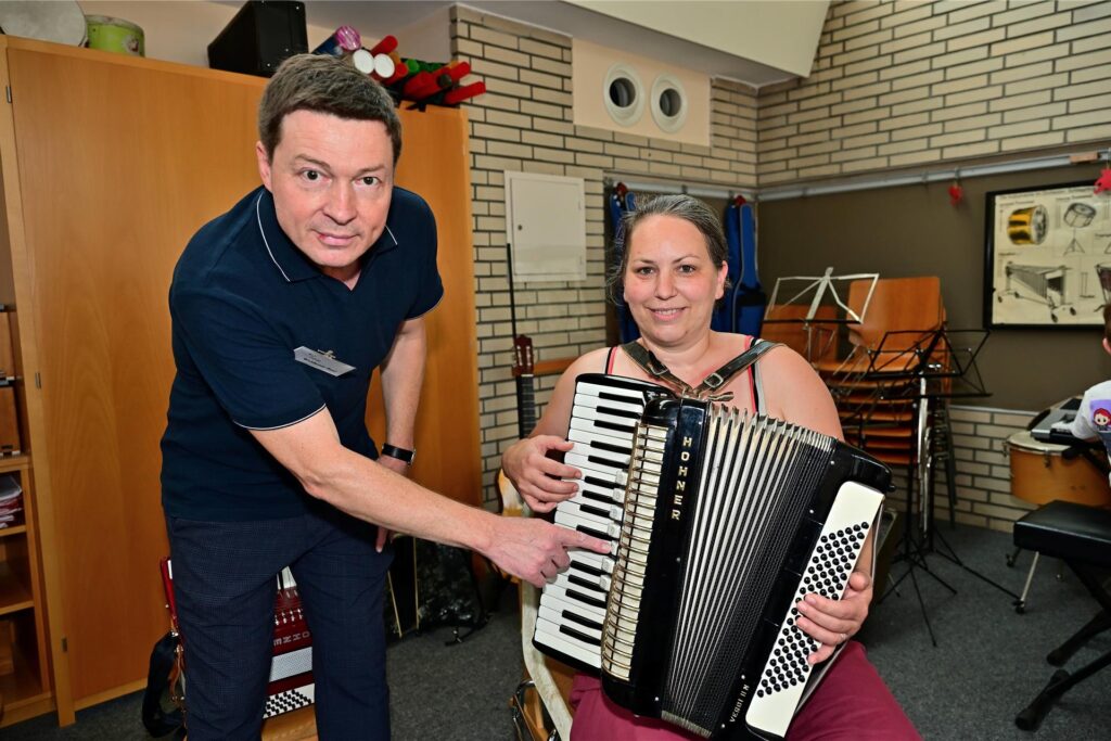Tag der offenen Tür in der städtischen Musikschule: Waldemar Baal erklärt Julia Sporkmann das Akkordeon