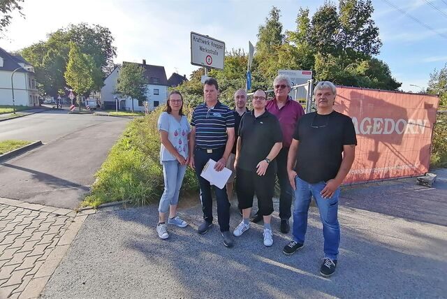 Anwohnergruppe vor einem offenen Bauzaun an der ehemaligen Kraftwerks-Zufahrt in Dortmund-Oestrich.
