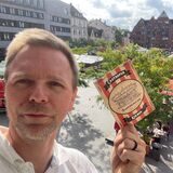 Tobias Weckenbrock mit einer Postkarte von der Castroper Kirmes. Sie wird am Eröffnungstag vom Stadtmarketing verteilt.