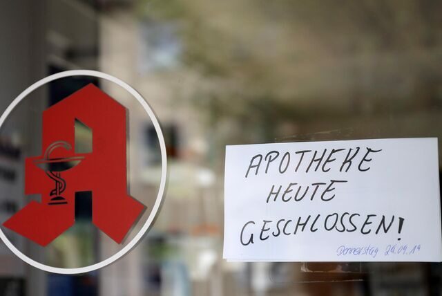 Ein Fenster mit einem Apotheken-Zeichen ist zu sehen. Daneben hängt ein Schild mit der Aufschrift: „Apotheke heute geschlossen.“
