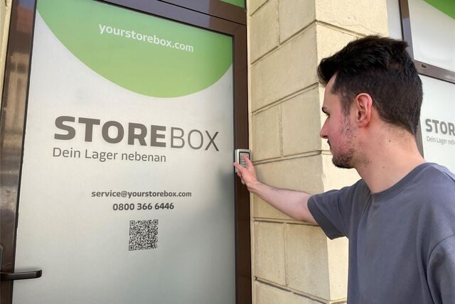 Ein Mann gibt einen Zahlencode an einer Storebox-Tür ein.