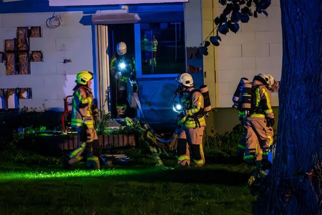 Feuerwehrleute mit Scheinwerfern am Brandort in einem Mehrfamilienhaus in Castrop-Rauxel.