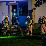 Feuerwehrleute mit Scheinwerfern am Brandort in einem Mehrfamilienhaus in Castrop-Rauxel.