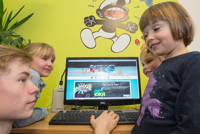 Der FSJ-ler Tom-Martin Schmidt mit den Kindern (l-r) Lotta, Lena und Christa an einem Computer am 17.12.2015 in Halle (Sachsen-Anhalt).