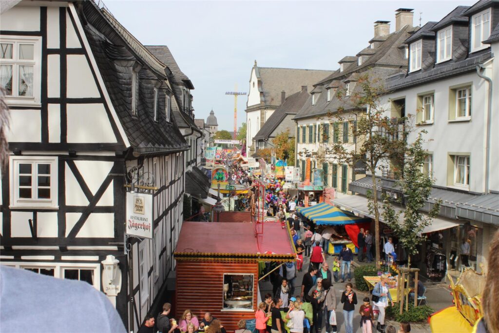 Besucher der Michaeliskirmes in Brilon gehen an den Ständen im Steinweg entlang. Besucher der Michaeliskirmes in Brilon gehen an den Ständen im Steinweg entlang.