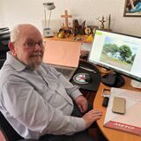 Der ehemalige Pfarrer Peter Seeber sitzt an seinem Schreibtisch. Auf dem PC-Schirm ein Bild vom Matthäus-Haus.