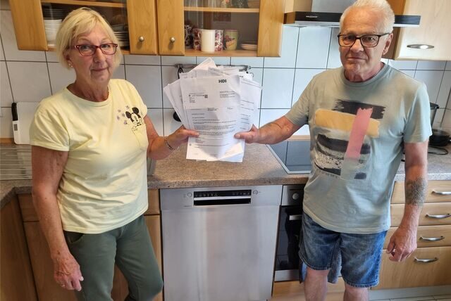 Ein Mann und eine Frau zeigen eine Menge Papierkram