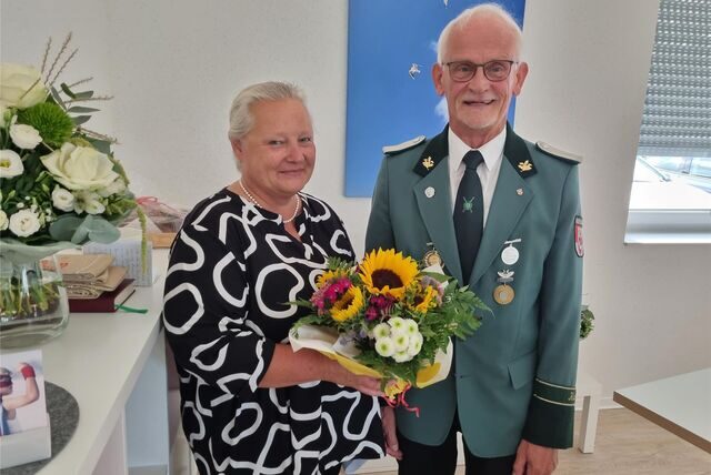 Eine Frau bekommt von einem Mann Blumen überreicht.