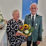 Eine Frau bekommt von einem Mann Blumen überreicht.