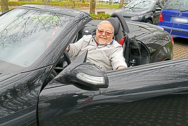 Ein älterer Mann steigt aus einem Auto aus.