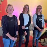 Drei Frauen stehen zusammen.