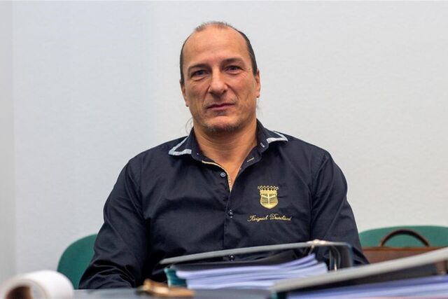 Peter Fitzek sitzt in einen Saal des Landgerichtes hinter Aktenordnern