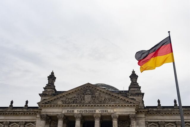 Eine Deutschland-Fahne weht am Tag der deutschen Einheit vor dem Reichstag.