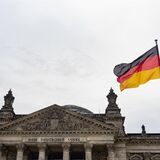 Eine Deutschland-Fahne weht am Tag der deutschen Einheit vor dem Reichstag.