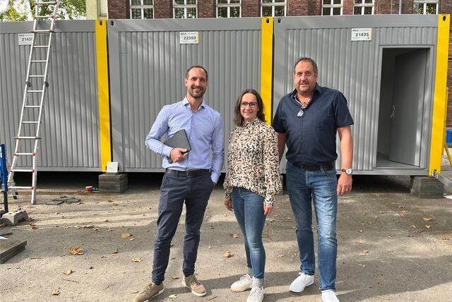 Michael Graetsch, Agnes Urban und Andreas Maske vor Containermodulen auf dem Schulhof der Comeniusschule.