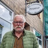Ein Mann steht vor einem Friseurgeschäft