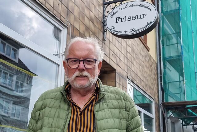 Ein Mann steht vor einem Friseurgeschäft