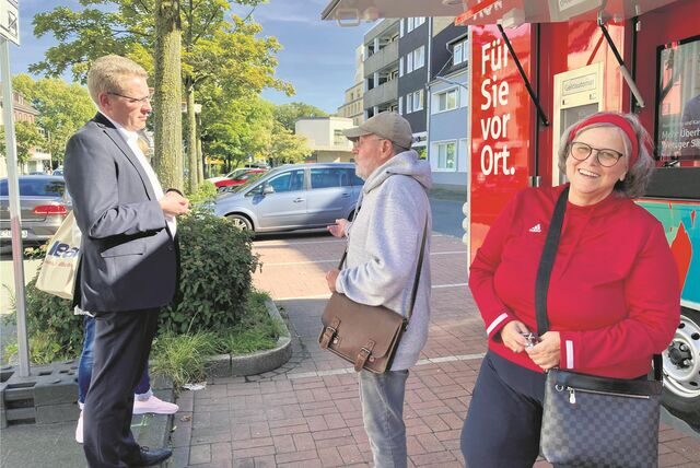 Sparkassen-Leiter Gerald Hövener diskutiert mit Kunden am Sparkassen-Bus.