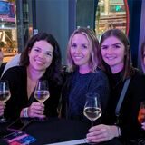 Fünf Frauen halten ein Getränk in der Hand und lächeln in die Kamera.