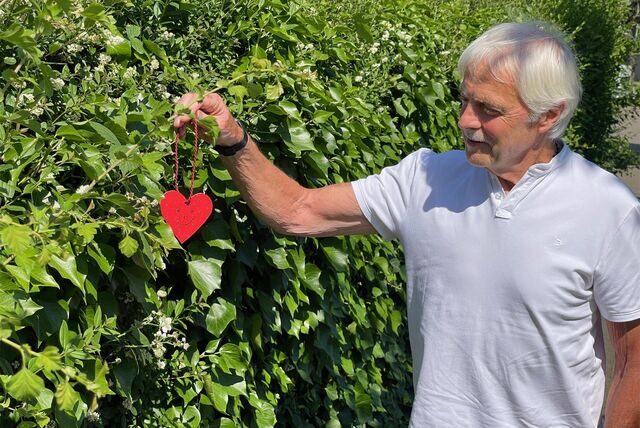 Hans Werner Diel am Schicksalsort in Werne. Zur Erinnerung an seinen Herzstillstand und seine Rettung hat er ein Herz an die Hecke gehängt.