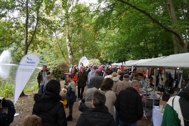 Viele Menschen strömen an Ständen vorbei durch den Volkspark.