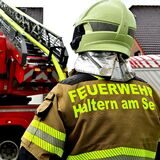 Ein Feuerwehrmann steht an einem Einsatzfahrzeug.