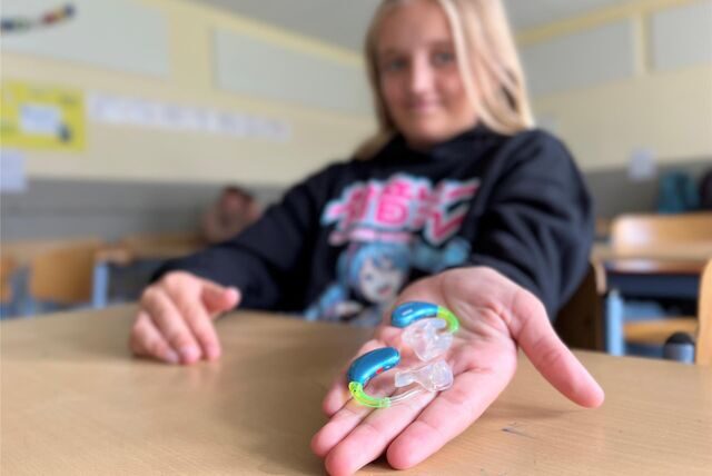 Mila Burmann zeigt ihre Hörgeräte.