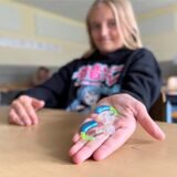 Mila Burmann zeigt ihre Hörgeräte.