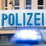 Ein Einsatzwagen der Polizei steht vor einer Dienststelle.