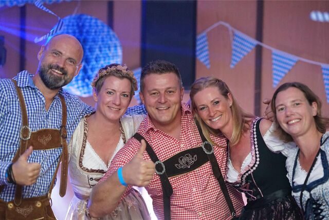 Fünf Menschen stehen nebeneinander und halten sich im Arm.